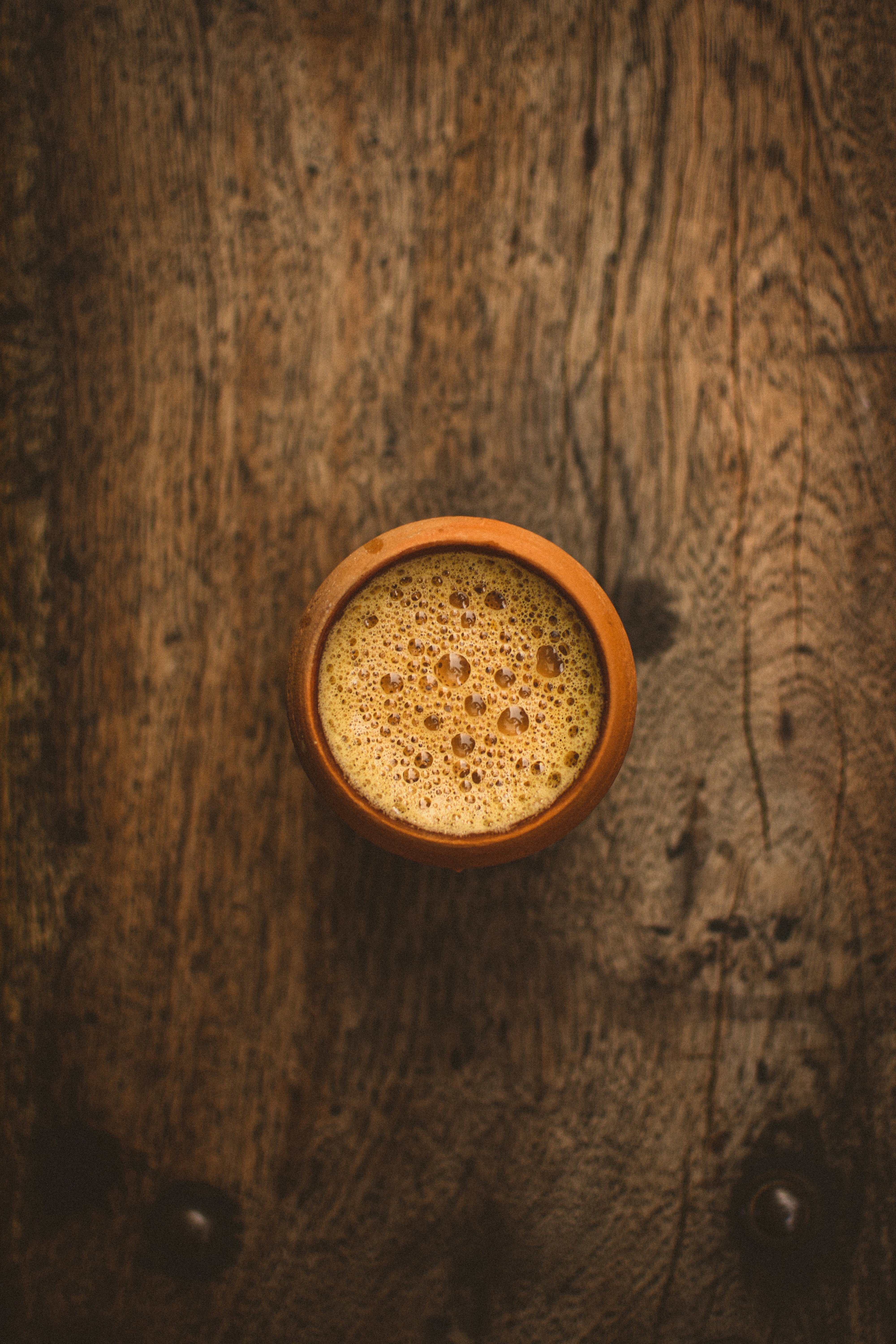 Ceramic cup with masala chai on a wooden surface